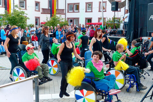 Aufführung mit bunten Puscheln der Wohngruppen der Behindertenhilfe