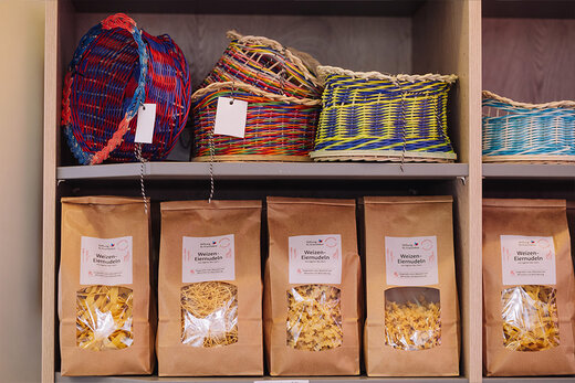 Nudelpackungen und bunte Körbe aus Eigenproduktion zum Verkauf im Laden