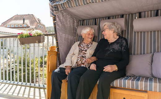 Zwei Seniorinnen sitzen in einem Strandkorb 