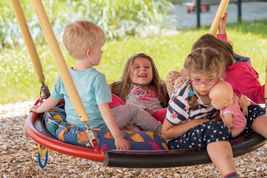 Kinder schaukeln im Schulkindergarten Zeno