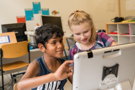 Junge und Mädchen lernen gemeinsam am Computer