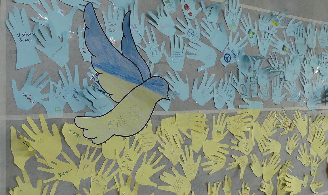 Mit einer selbstgebastelten Flagge und einer Friedenstaube möchten die Kinder ihre Verbundenheit zur Ukraine ausdrücken.
