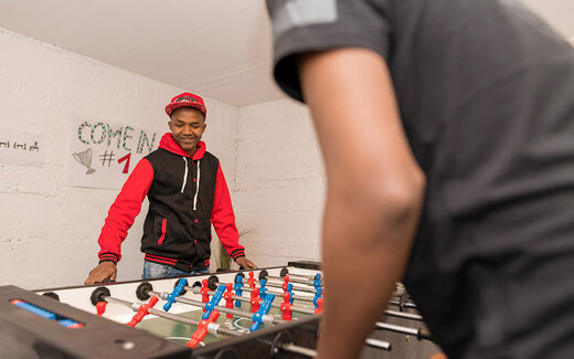 Jugendliche spielen gemeinsam Tischkicker in der Jugendwohngemeinschaft Raphael