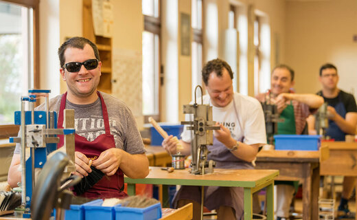 Erwachsene arbeiten gemeinsam in der Werkstatt für Menschen mit Behinderung 