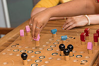 Zwei Personen spielen "Mensch ärgere dich nicht" als taktiles Spiel