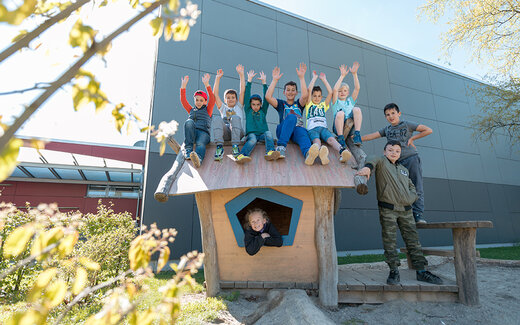 Kinder sitzen auf Spielhaus und Jubeln
