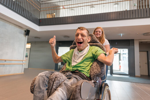 Kind im Rollstuhl gemeinsam mit seiner Betreuerin