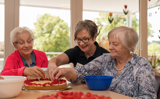 Drei Seniorinnen backen gemeinsam einen Kuchen 
