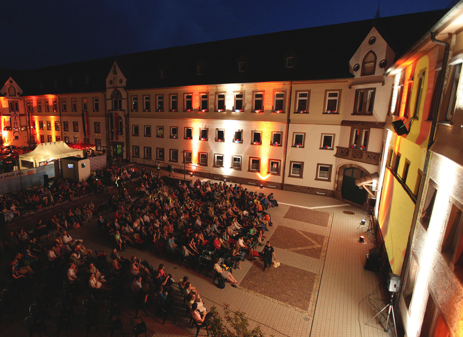 Abendstimmung im beleuchteten Klosterhof mit den Stühlen und der Leinwand vom Open Air Kino