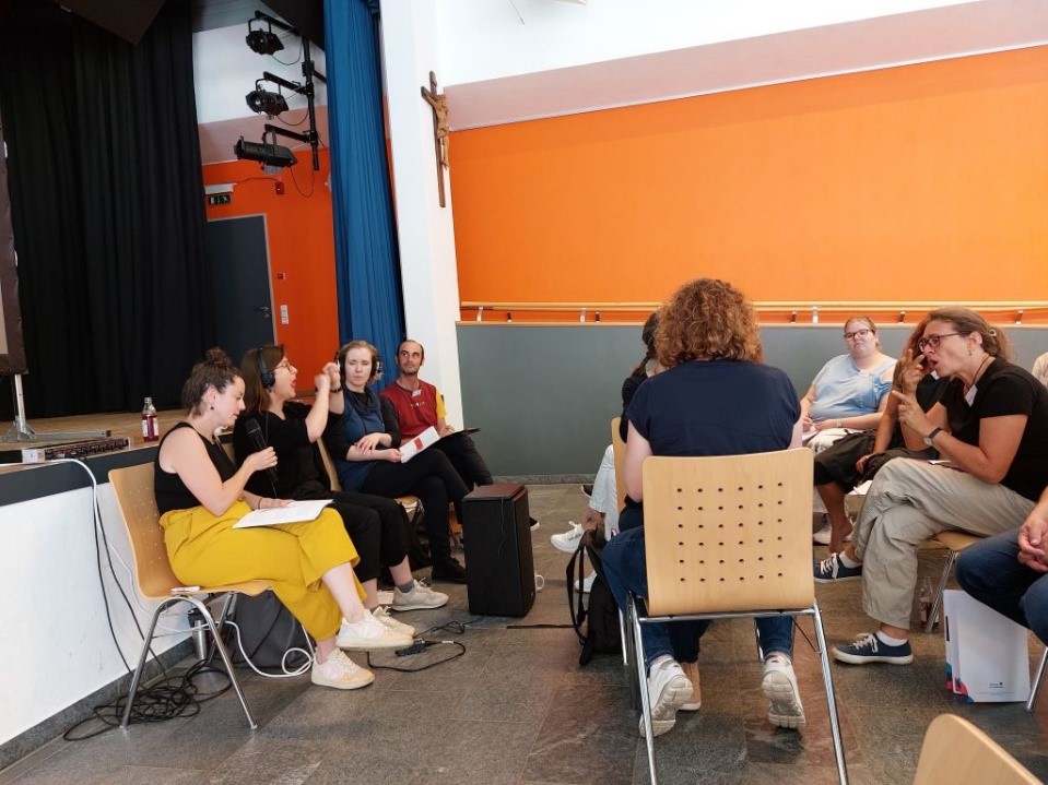 Kommunikations-Hochleistungszentrum mit simultaner Übersetzung von Englisch in Deutsch sowie in Gebärdensprache und taktile Gebärdensprache.