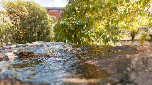 Quellwasser fließt über einen Steinbrunnen
