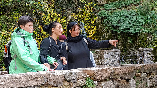 Ausflug nach Assisi - drei Frauen an einer Mauer stehend - eine davon ist eine Franziskanerin von Heiligenbronn